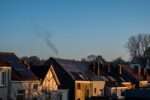 Widok na rzędy domów jednorodzinnych z zainstalowanymi na dachach panelami fotowoltaicznymi.
