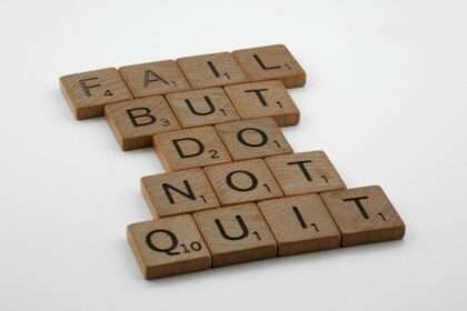 Drewniane płytki z literami ułożone w napis: Fail but do not quit.