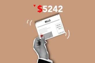 Dłoń trzymająca kartkę z napisem „BILLS” i zestawieniem wydatków na beżowym tle.