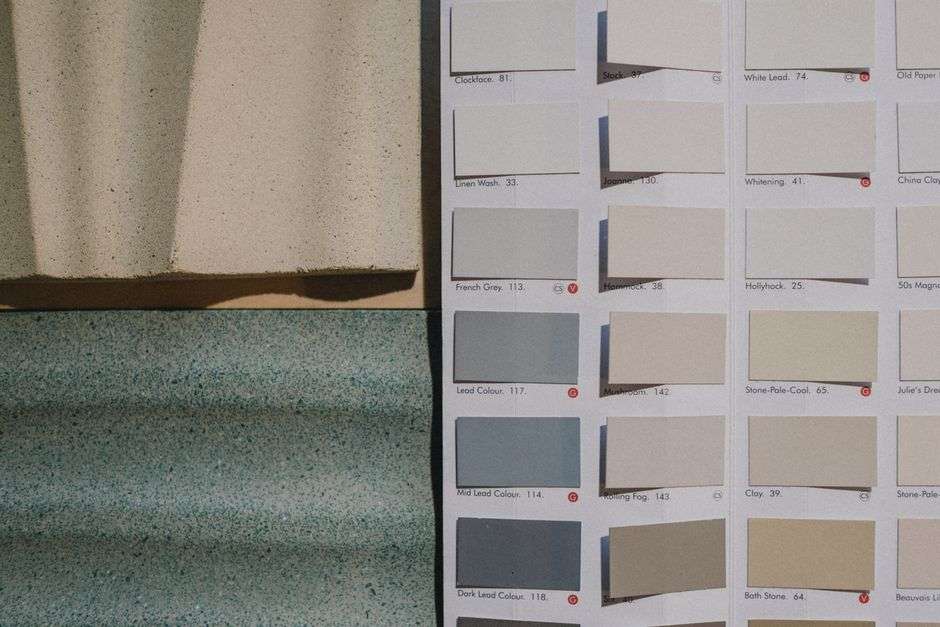 Próbki kolorów farb zestawione z teksturami betonu i niebieskiego materiału.