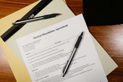 Długopis leżący na dokumencie o tytule Marital Dissolution Agreement na drewnianym stole.