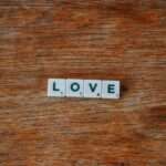 Drewniane płytki do gry w scrabble tworzące napis LOVE na drewnianym stole.